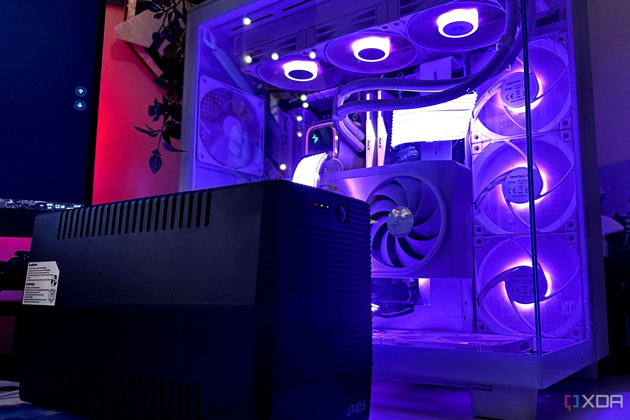 Bộ lưu điện UPS màu đen đặt cạnh thùng máy tính gaming, bảo vệ thiết bị khỏi sự cố điện