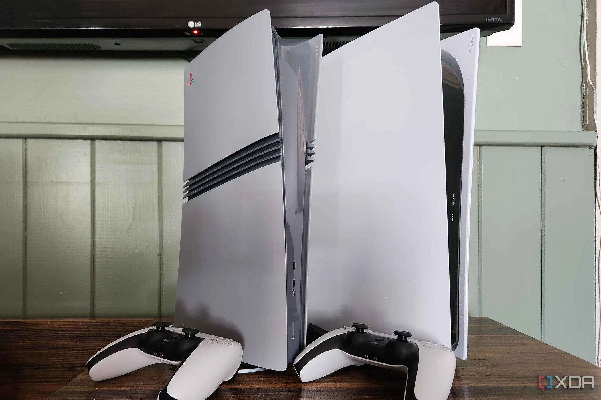 Các máy chơi game PlayStation 5 và tay cầm trên bàn, biểu tượng cho sự tiện lợi và chi phí hợp lý của console gaming so với PC gaming đắt đỏ.