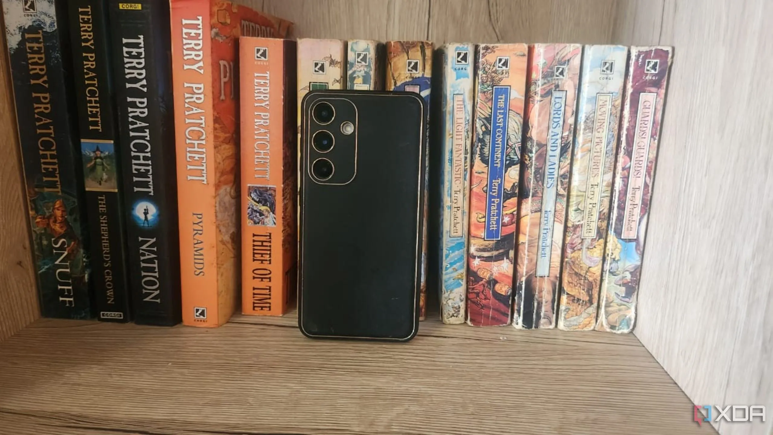 Điện thoại cũ được đặt trên giá sách để làm camera an ninh, cho thấy khả năng linh hoạt trong vị trí đặt.