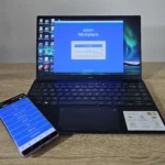 Điện thoại điều khiển laptop đang hiển thị giao diện Zoom, tượng trưng cho quá trình quản lý tài khoản và hủy đăng ký Zoom Pro.
