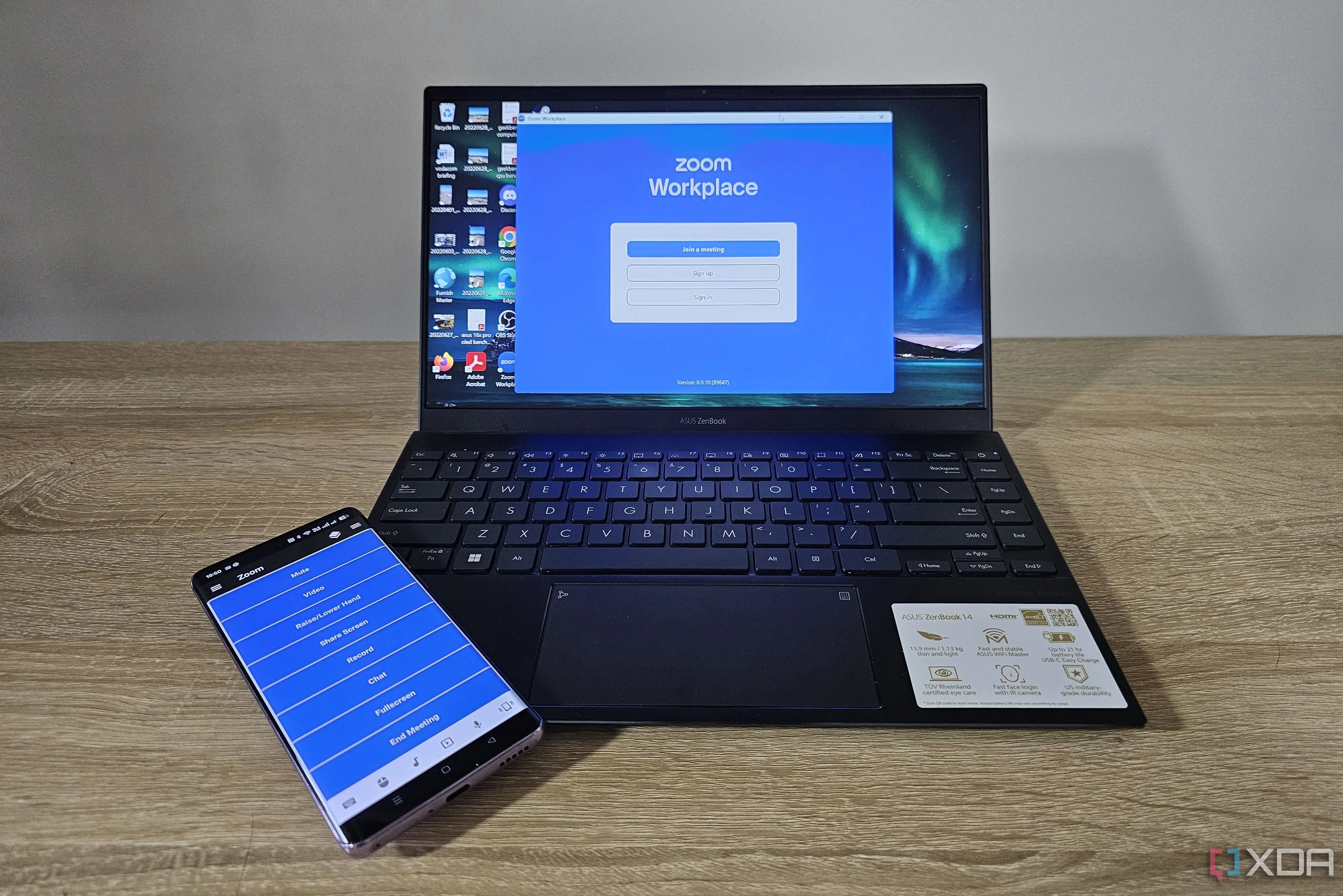 Điện thoại điều khiển laptop đang hiển thị giao diện Zoom, tượng trưng cho quá trình quản lý tài khoản và hủy đăng ký Zoom Pro.