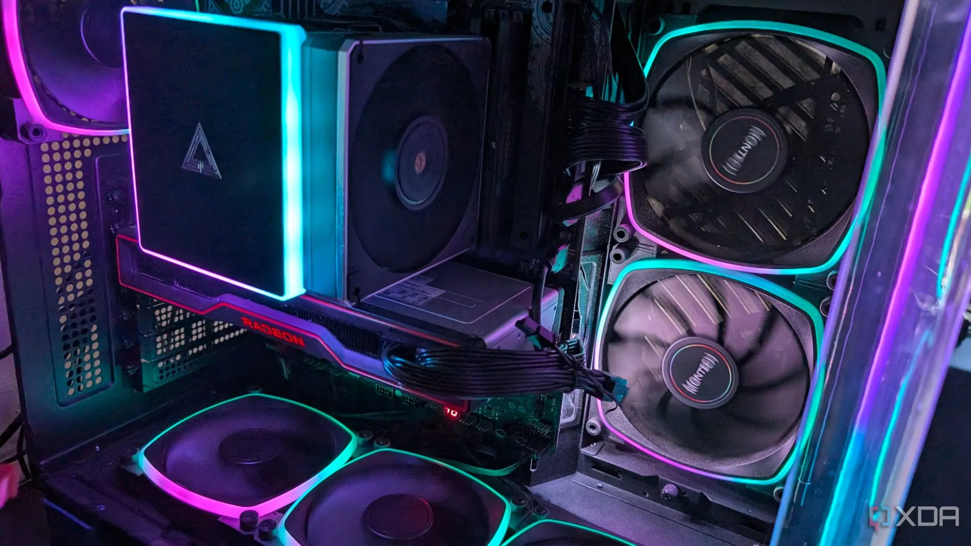 Hệ thống PC gaming với đèn RGB nổi bật và card đồ họa AMD chiếm nhiều không gian, có thể ảnh hưởng luồng khí đến SSD