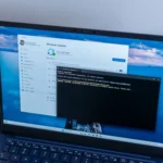 Laptop Windows 11 hiển thị giao diện PowerShell đang xử lý, minh họa công cụ hỗ trợ khắc phục lỗi cập nhật KB5055523.