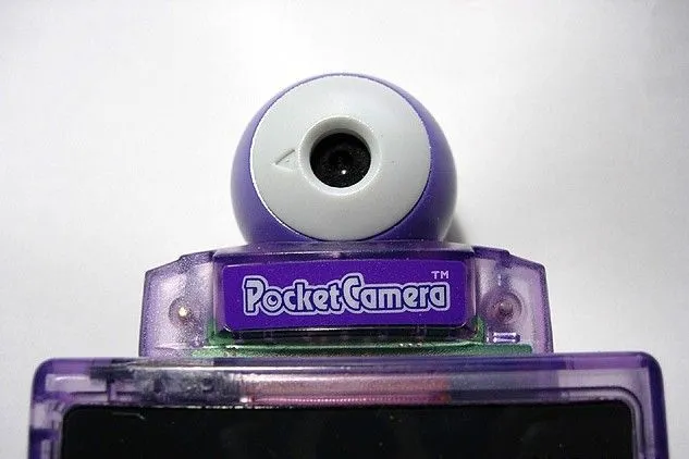 Máy ảnh Nintendo Pocket Camera màu xám gắn trên Game Boy màu tím, phụ kiện chụp ảnh di động tiên phong