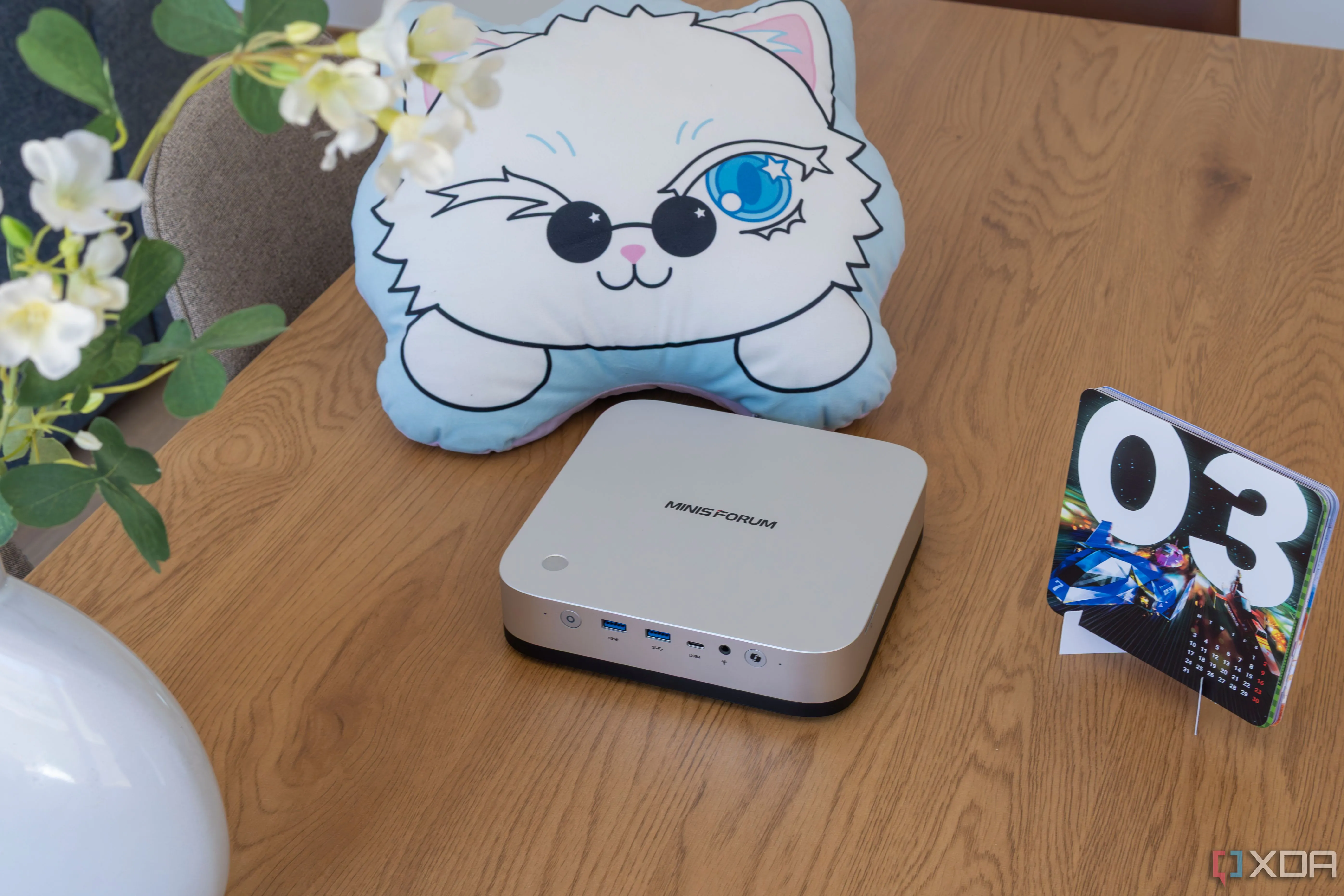 Minisforum AI X1 Pro đặt trên bàn gỗ, góc nhìn toàn diện về kích thước thực tế của PC mini