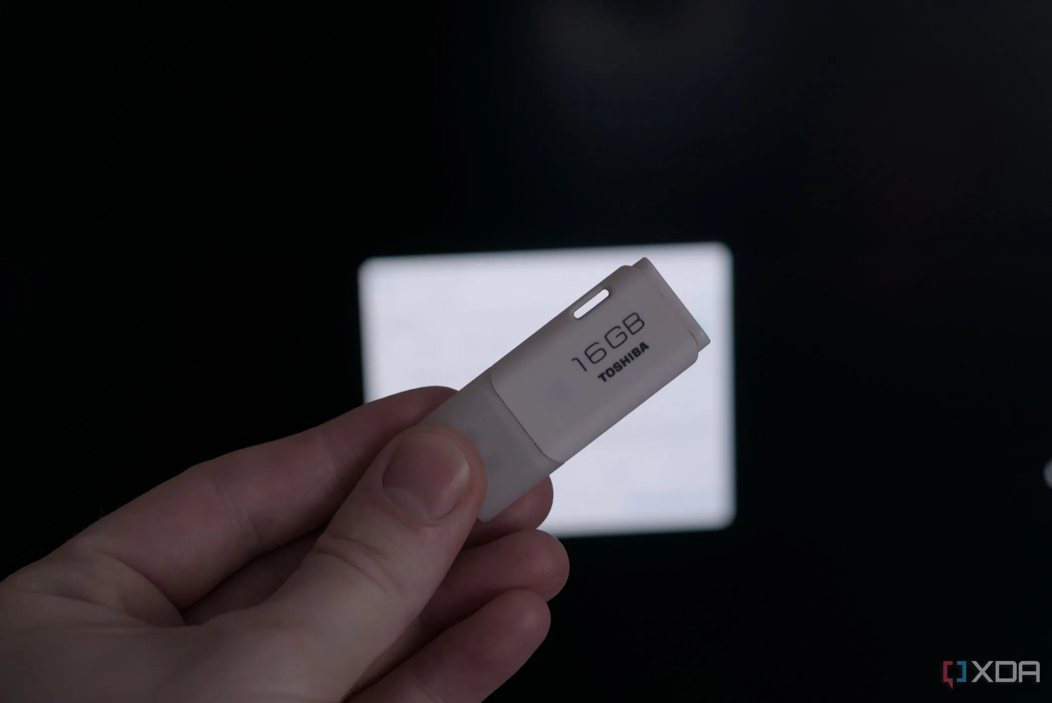 Một bàn tay đang cầm thiết bị USB nhỏ gọn