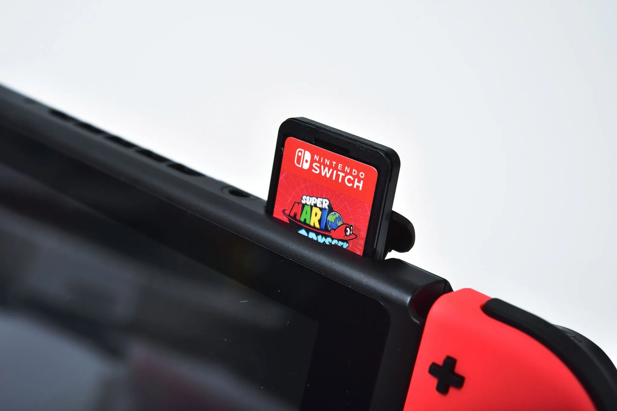 Một chiếc máy console Nintendo Switch đang cắm thẻ game vào khe, biểu tượng của hệ sinh thái game độc đáo của Nintendo
