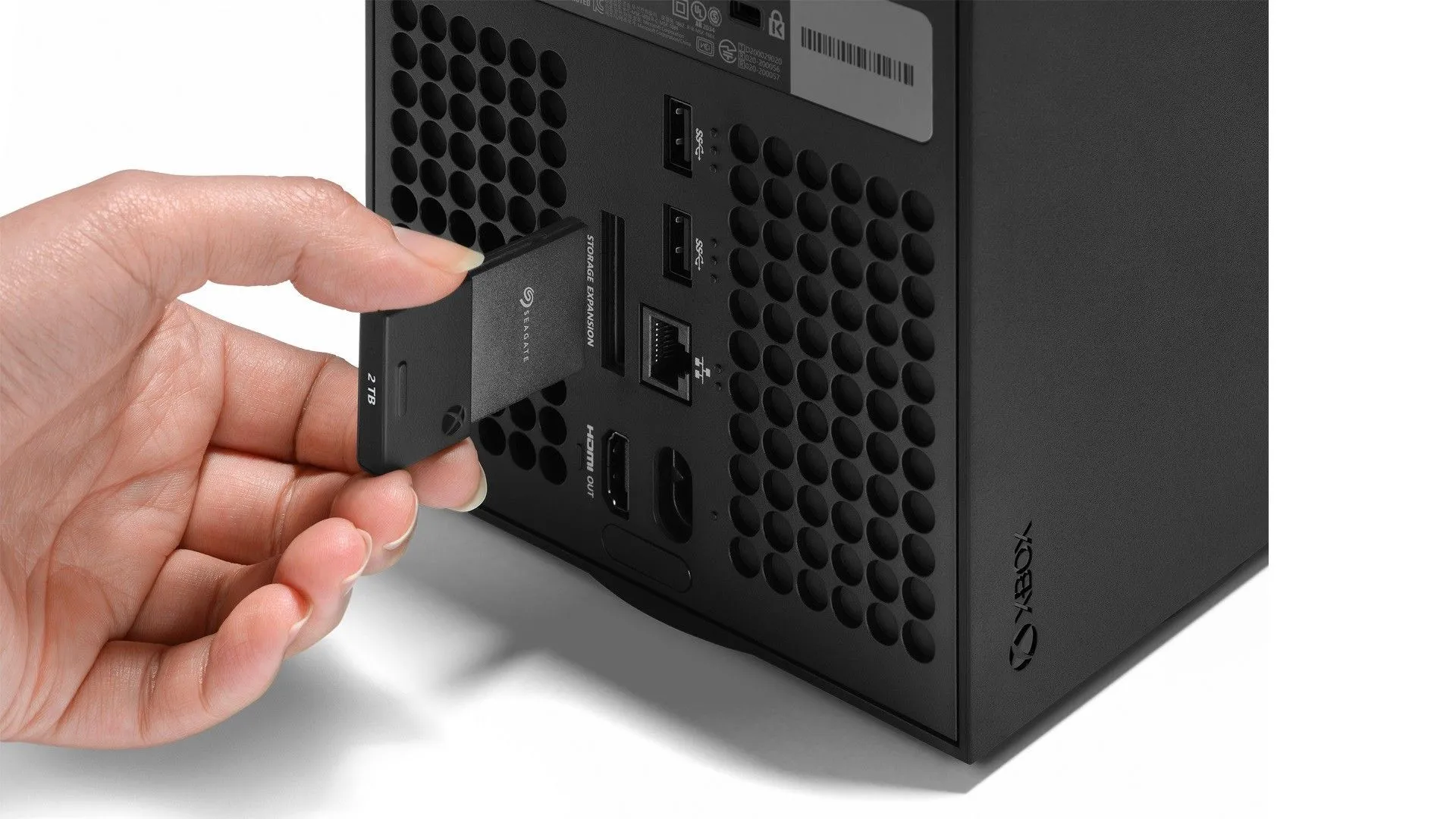 Một chiếc thẻ SSD mở rộng chuyên dụng đang được cắm vào mặt sau của console Xbox Series X, minh họa phương thức nâng cấp bộ nhớ hiện tại của Xbox.