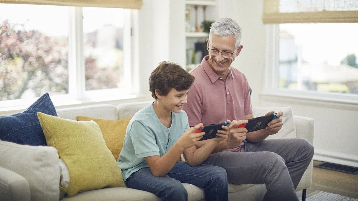 Một người đàn ông và một cậu bé đang vui vẻ chơi game trên Nintendo Switch, thể hiện tính thân thiện với gia đình của hệ máy này