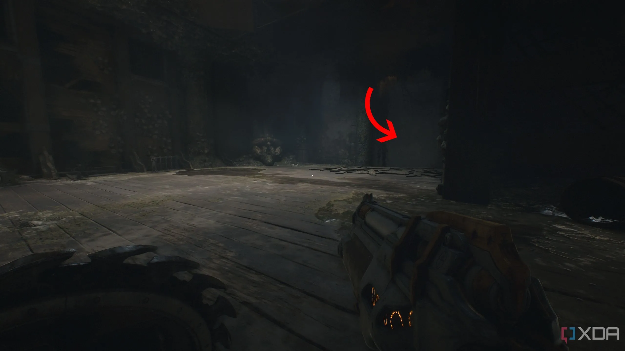 Mũi tên chỉ đến một lối vào ẩn trong căn phòng tối trong Chương 14 Doom The Dark Ages.