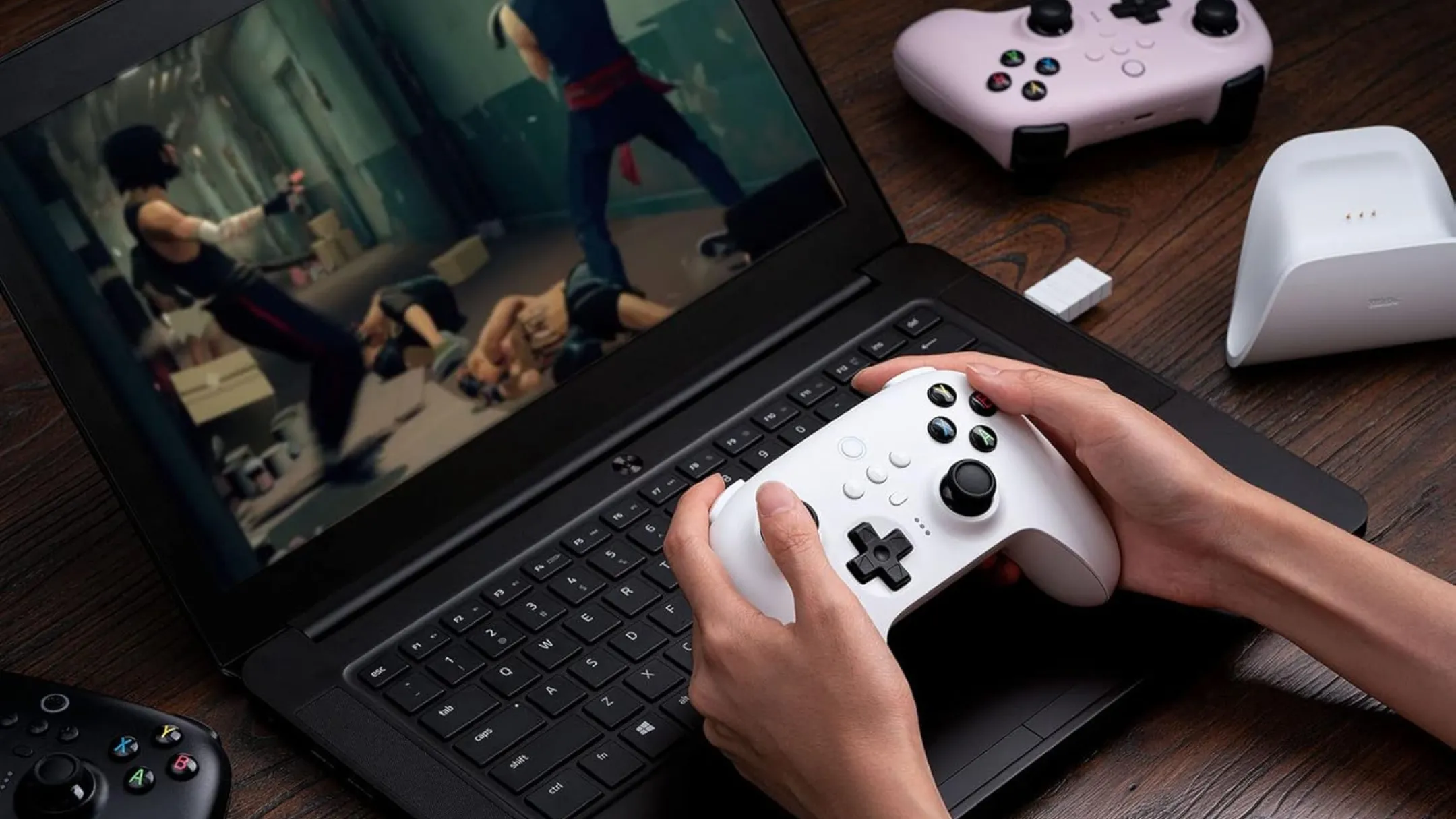 Người dùng chơi game trên laptop với tay cầm không dây 8BitDo Ultimate