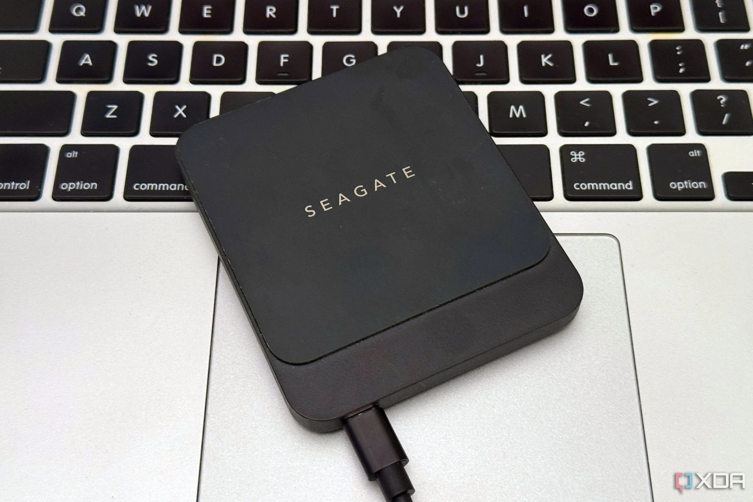 Ổ cứng SSD ngoài được đặt trên touchpad của Macbook, thể hiện khả năng mở rộng bộ nhớ hiệu suất cao